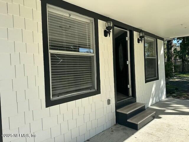 entrance to property featuring concrete block siding