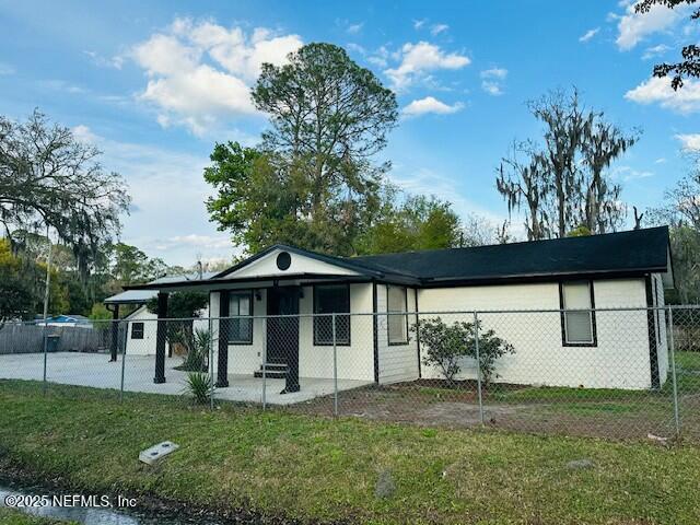 ranch-style house with a fenced front yard and a front lawn