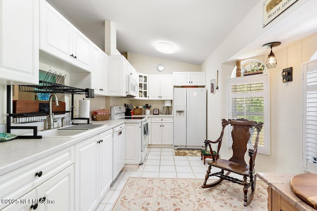 kitchen featuring white appliances, light tile patterned floors, lofted ceiling, light countertops, and a sink