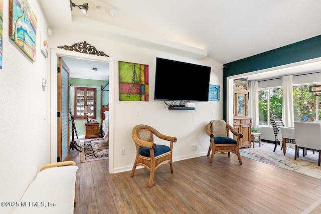 sitting room with visible vents, baseboards, and wood finished floors