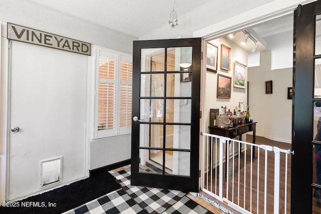 interior space with lofted ceiling, rail lighting, and baseboards