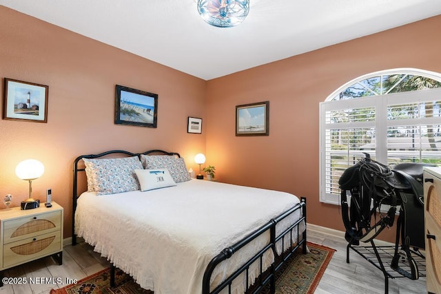 bedroom with baseboards and wood finished floors