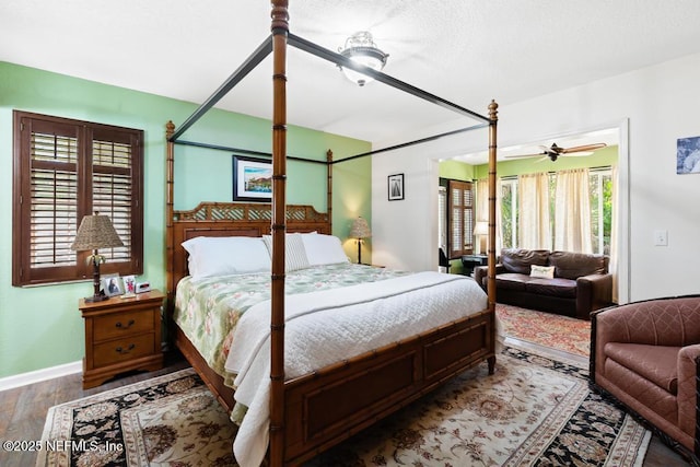 bedroom featuring multiple windows, baseboards, and wood finished floors