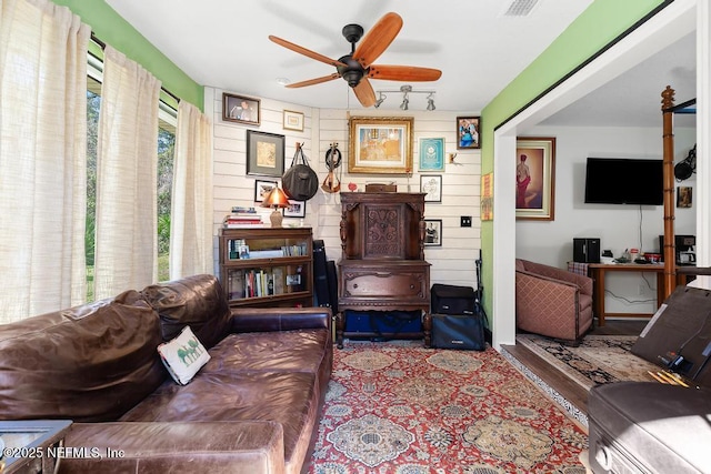 living room featuring a ceiling fan and visible vents