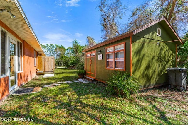 view of yard with fence and an outbuilding