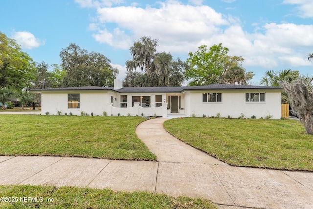 ranch-style home with stucco siding and a front yard