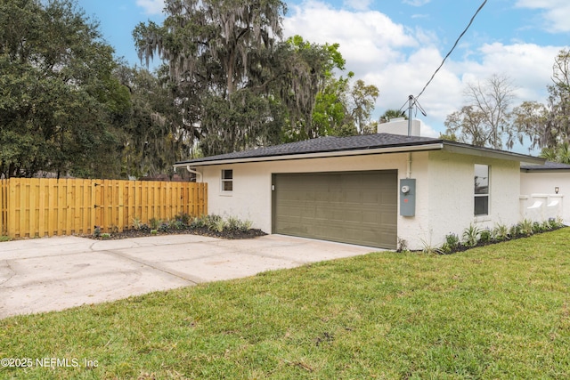 garage featuring concrete driveway and fence