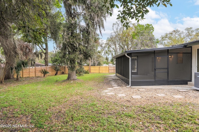 view of yard with a fenced backyard and a sunroom