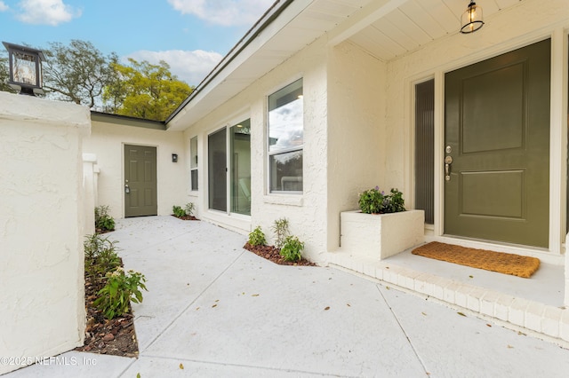 entrance to property with a patio area and stucco siding