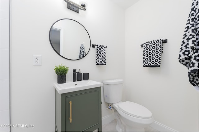 bathroom featuring baseboards, vanity, and toilet