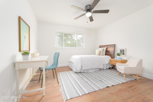 bedroom with baseboards, a ceiling fan, and light wood-style floors