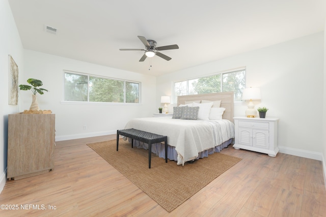 bedroom featuring light wood-style floors, multiple windows, and baseboards