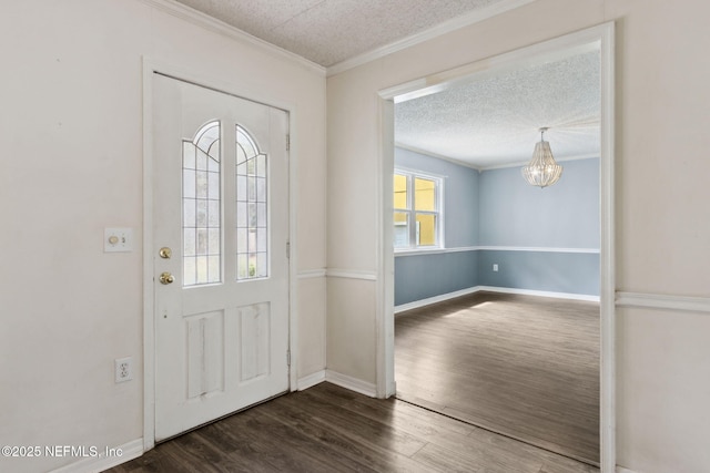 foyer with baseboards, ornamental molding, wood finished floors, an inviting chandelier, and a textured ceiling