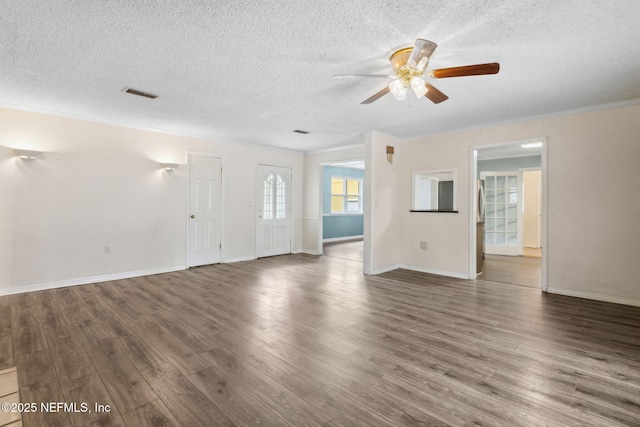 unfurnished living room featuring a textured ceiling, ornamental molding, wood finished floors, and visible vents