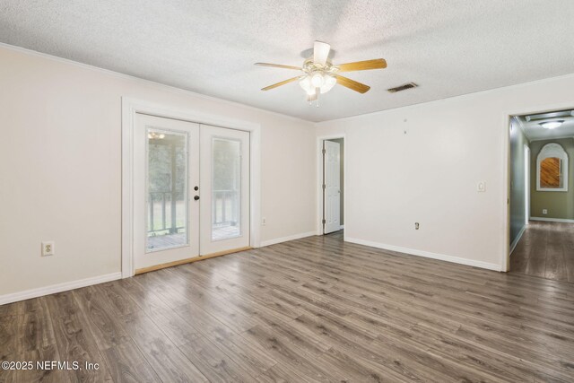 spare room featuring a textured ceiling, french doors, wood finished floors, and visible vents