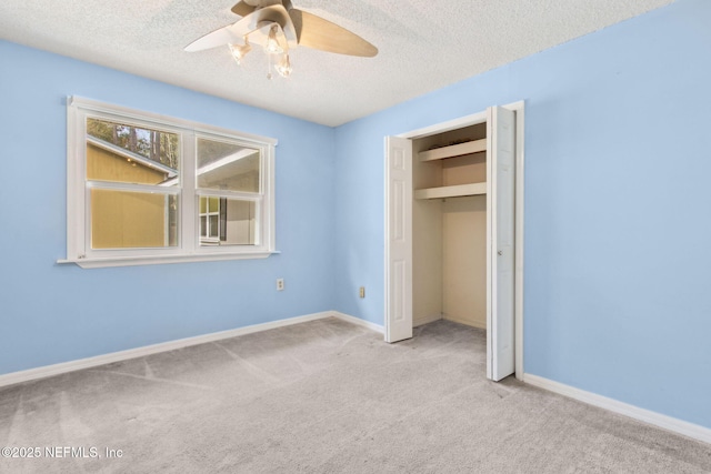 unfurnished bedroom featuring a textured ceiling, carpet floors, a closet, and baseboards