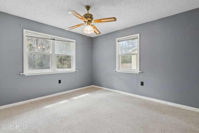 carpeted spare room with ceiling fan, baseboards, and a textured ceiling