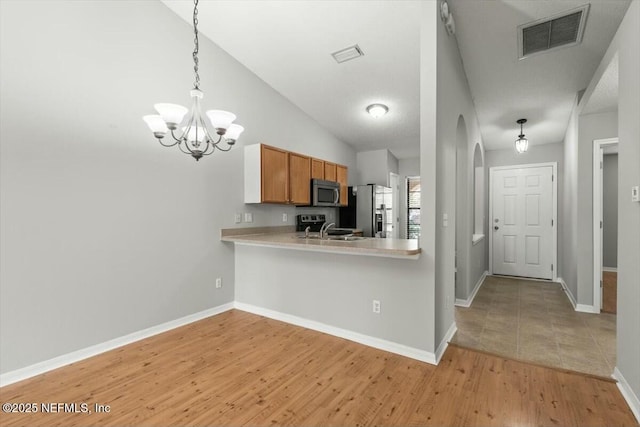 kitchen with visible vents, brown cabinets, a sink, stainless steel appliances, and light countertops