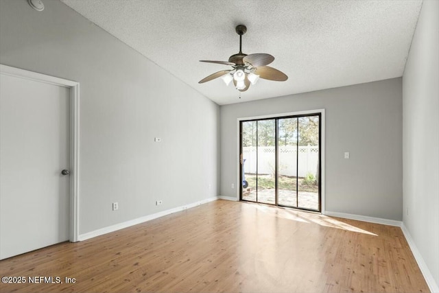 spare room with baseboards, a textured ceiling, ceiling fan, and wood finished floors