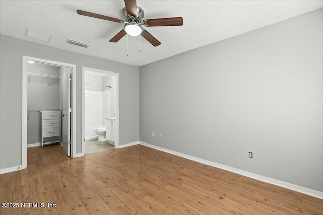 unfurnished bedroom with visible vents, baseboards, a closet, and a spacious closet