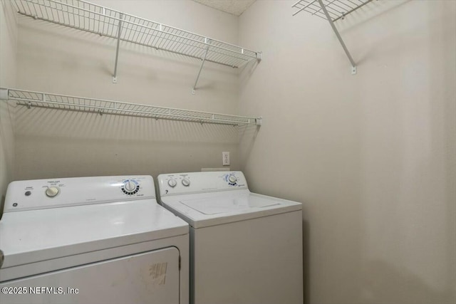 clothes washing area with laundry area and washer and clothes dryer