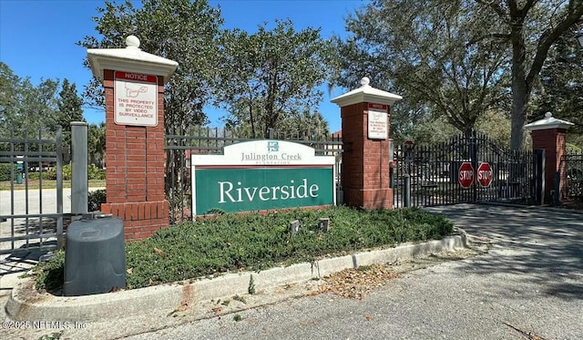 community sign featuring a gate and fence