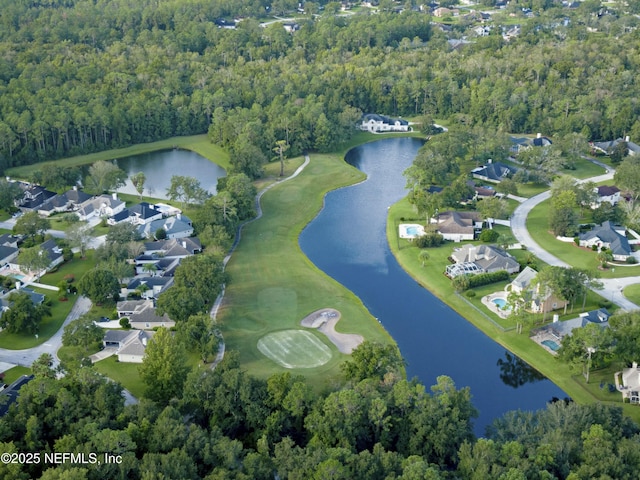 drone / aerial view featuring a view of trees, a water view, and a residential view