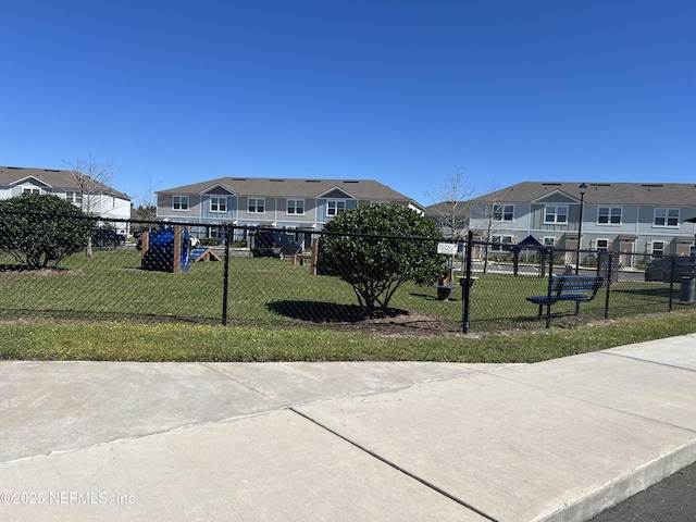 surrounding community with a residential view, a yard, and fence