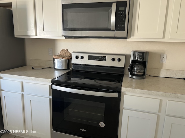 kitchen with light countertops, appliances with stainless steel finishes, and white cabinets