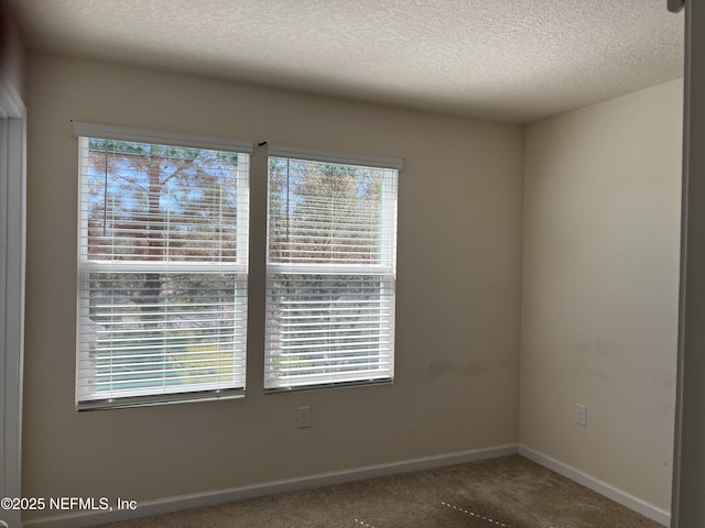 unfurnished room featuring a textured ceiling, baseboards, and carpet flooring