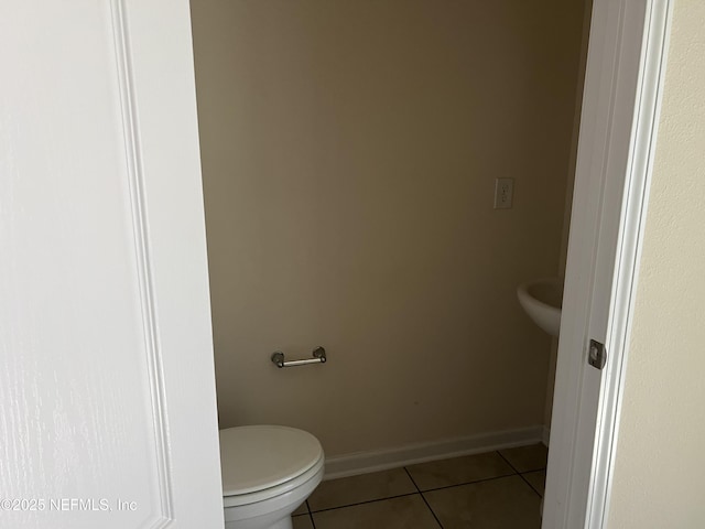 bathroom featuring baseboards, toilet, and tile patterned floors