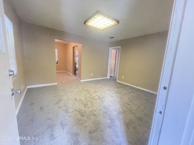 empty room featuring carpet flooring and baseboards