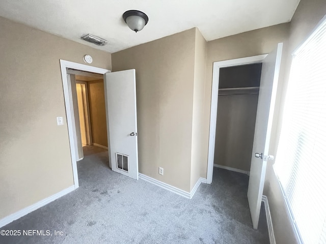 unfurnished bedroom with a closet, carpet flooring, visible vents, and baseboards