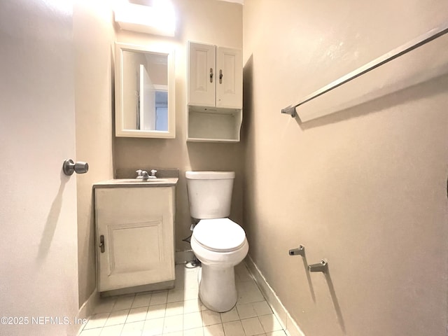 bathroom with toilet, tile patterned floors, baseboards, and vanity