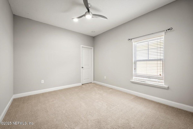 unfurnished room featuring baseboards, light colored carpet, and ceiling fan