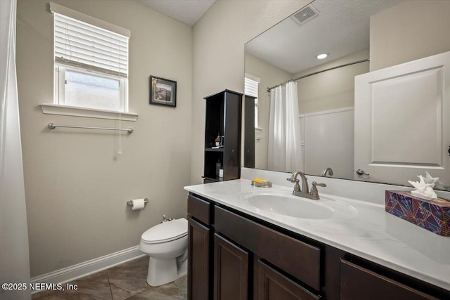 bathroom featuring vanity, baseboards, visible vents, tile patterned floors, and toilet