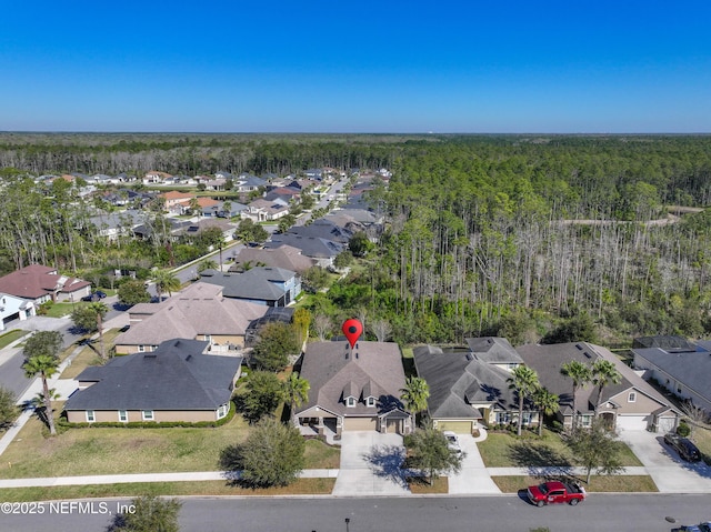 birds eye view of property featuring a residential view and a wooded view