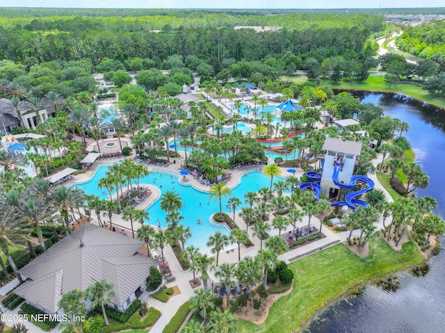 birds eye view of property featuring a forest view and a water view