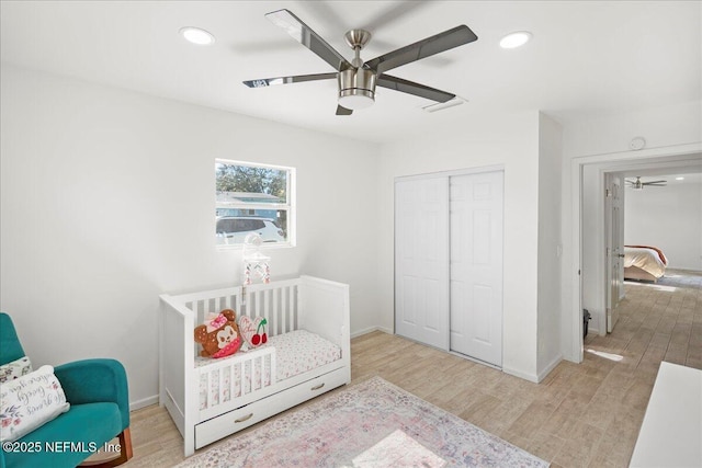 bedroom featuring a closet, recessed lighting, baseboards, and wood finished floors