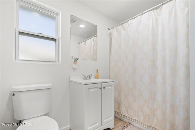 bathroom with toilet, wood finished floors, and vanity