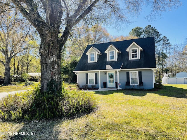 cape cod-style house with a front yard and fence