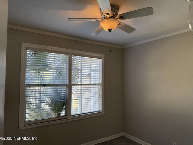 spare room with baseboards, ornamental molding, and a ceiling fan