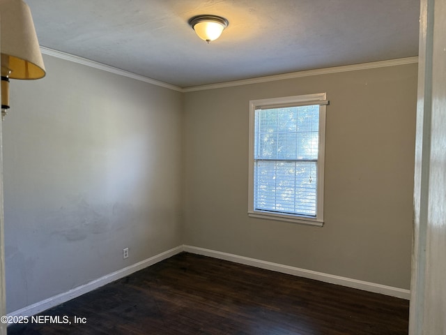 spare room featuring baseboards, dark wood finished floors, and ornamental molding