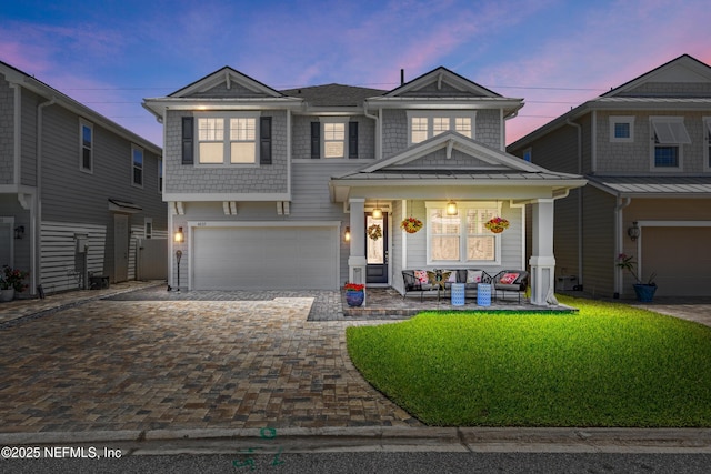 view of front of home featuring covered porch, decorative driveway, and an attached garage