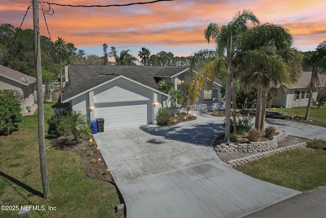 view of front facade with a garage, a front yard, concrete driveway, and stucco siding