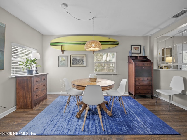 dining room featuring a wealth of natural light, baseboards, visible vents, and wood finished floors