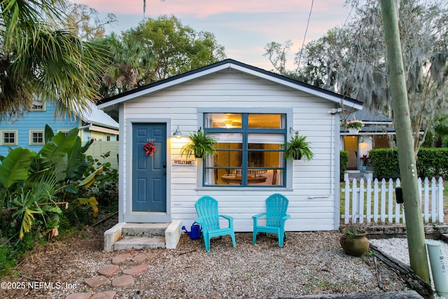 bungalow featuring fence