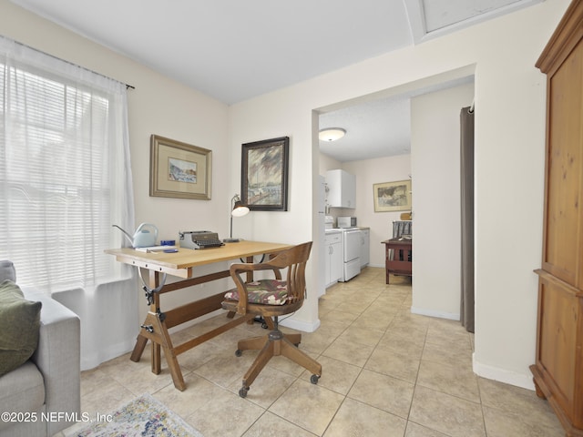 office with light tile patterned floors, washer and clothes dryer, and baseboards