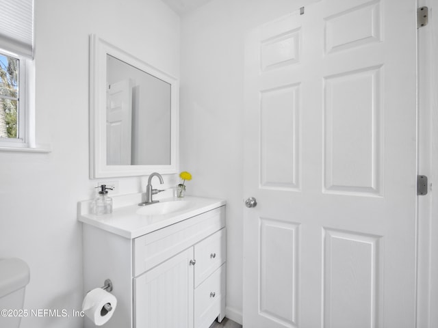 half bathroom with vanity and toilet