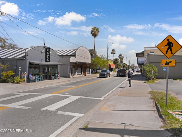 view of road with curbs, traffic signs, and sidewalks